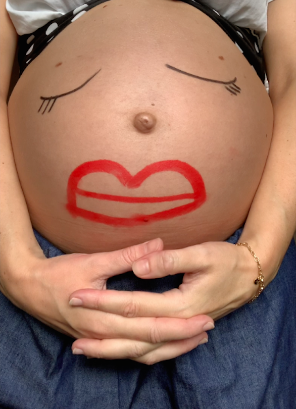 Preganant belly with make up face on bump.